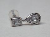 une photo d'une paire de boucles d'oreilles en diamant posées sur une surface blanche