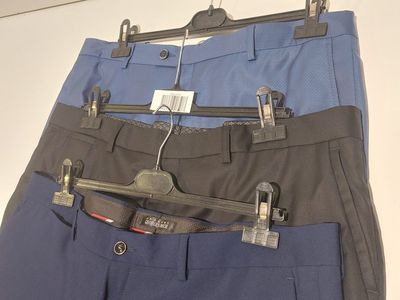 three pairs of pants hanging on a hanger