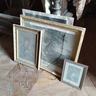 trois tableaux encadrés posés par terre à côté d'un miroir