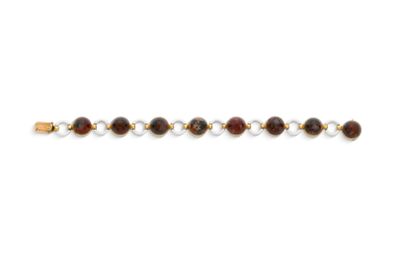un gros plan d'un bracelet orné de perles sur un fond blanc