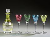 four different colored wine glasses and a decanter sitting on a table
