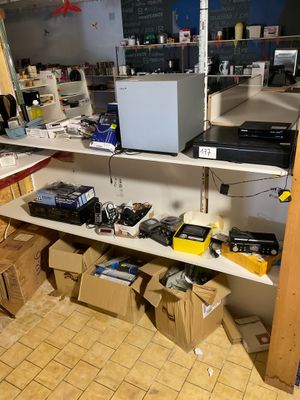 une pièce remplie de cartons, avec un ordinateur posé sur une étagère