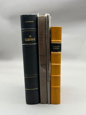 trois livres sont empilés sur une surface blanche