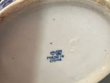 a close up of a blue and white vase on a table