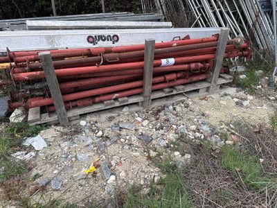 un tas de tuyaux posé par terre près d'une clôture
