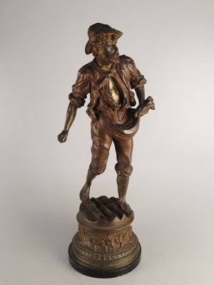 bronze statue of a man with a hat and a cane