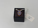 une photo d'un collier dans un coffret muni d'une étiquette