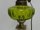 a green glass lamp that is sitting on a table