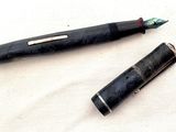 un stylo noir et un stylo rouge posés sur un tissu blanc