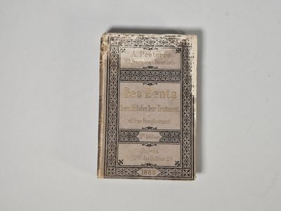 un vieux livre posé sur une table à côté d'un mur blanc