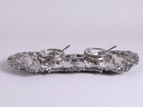 un plateau en argent ancien sur lequel sont posées deux tasses et deux cuillères