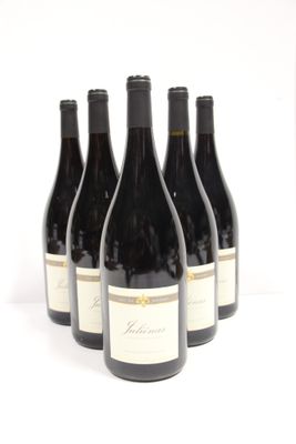six bottles of wine are lined up in a row on a white surface