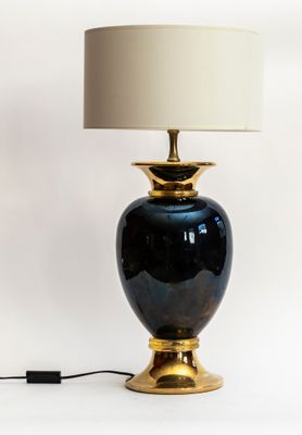 une lampe noire et dorée avec un abat-jour blanc