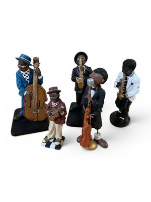 quatre figurines représentant différents musiciens sur fond blanc