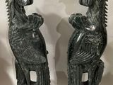 deux statues représentant un oiseau et un autre oiseau, l’un posé sur l’autre
