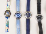 five different watches sitting on a table next to each other