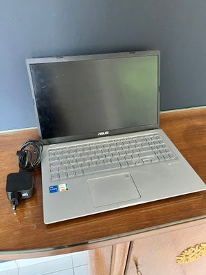 a laptop computer sitting on a desk with a charger on it