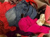 a suitcase full of clothes and clothes sitting on the floor