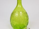 a green glass vase with a glass stopper next to it