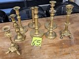 five brass candlesticks on a table with a price tag