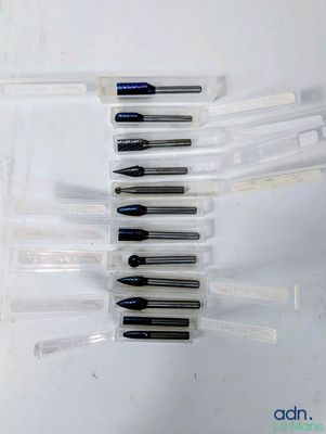 Plusieurs stylos sont alignés en rangée sur une surface blanche