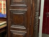 une grande armoire en bois dans une pièce dont la porte est rouge