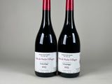 deux bouteilles de vin rouge posées l'une à côté de l'autre sur une table