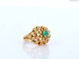 a close up of a gold ring with a green stone