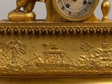 a gold clock that is sitting on top of a table