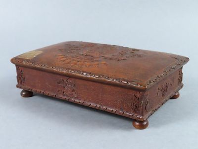 une vieille boîte en bois posée sur une surface blanche