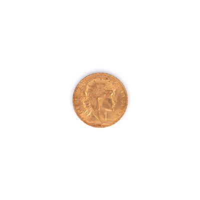 gros plan d'une pièce d'or sur une surface blanche