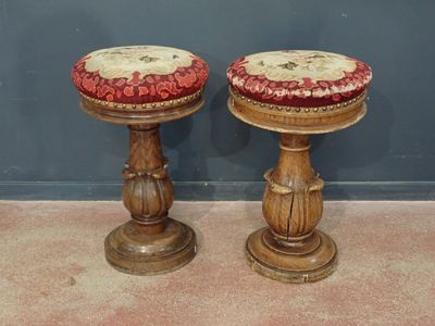 two wooden stools with red and white cushions on them