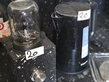 a black counter top with a blender and a glass container on it