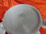 a white cup and saucer sitting on an orange cloth