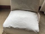 a chair that has a pillow on it in front of a window