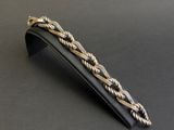 gros plan d'un bracelet en argent sur une surface noire