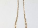 un collier de perles blanches avec un fermoir noir sur fond blanc
