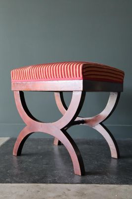 un banc sur lequel est posé un coussin rayé rouge et blanc