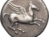 an ancient silver coin with a winged horse on it ' s back