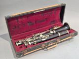 a black and silver clarinet in a case on a white surface