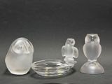 trois figurines en verre représentant des chouettes et un bol posés sur une table
