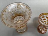 two glass vases sitting next to each other on a table