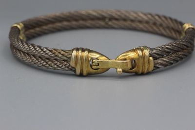 un gros plan sur un bracelet en corde muni d'un fermoir en or
