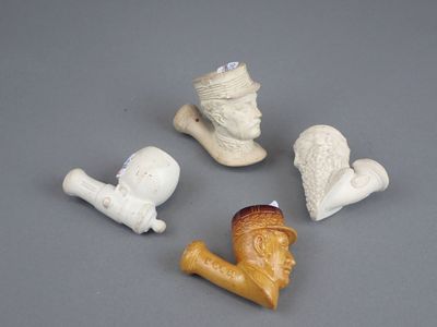 quatre petites figurines de formes et de tailles différentes posées sur une surface grise
