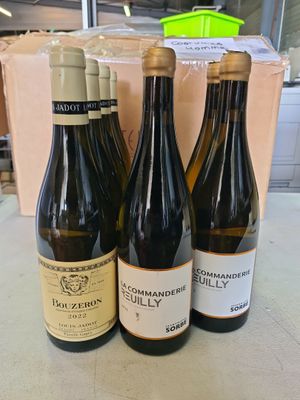 trois bouteilles de vin sont posées sur une table devant une boîte