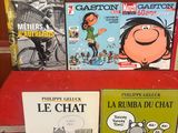 plusieurs livres sur une étagère rouge dans une pièce au mur rouge