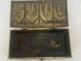 an old brass box with a lock on a white surface