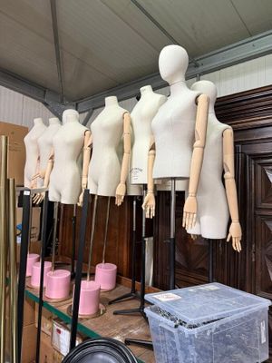 de nombreux mannequins alignés sur une étagère dans une pièce