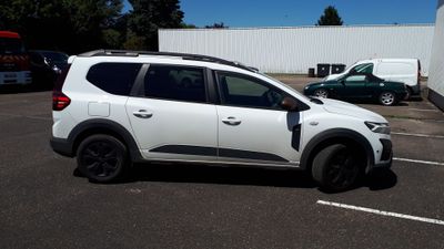 un SUV blanc garé sur un parking à côté d'un camion
