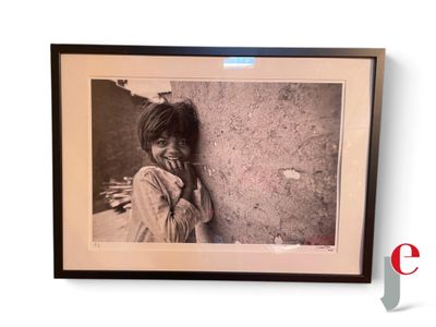 an old photo of a young girl leaning against a wall
